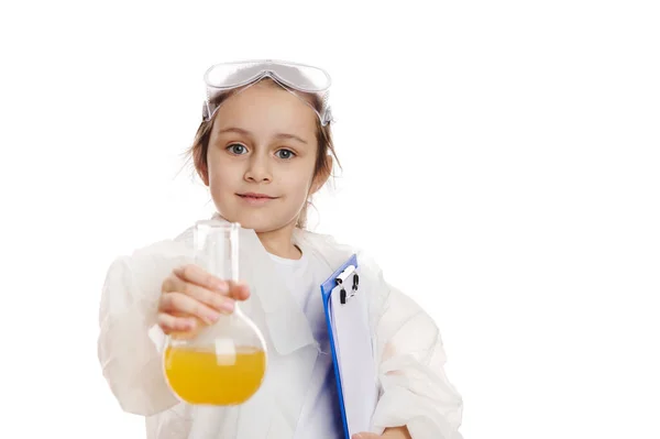 白地に黄色の液体の化学物質で研究室のフラスコを保持しながら 研究室のコートの魅力的なスマート女子高生は カメラで笑顔 子供は化学を学ぶ 教育理念 — ストック写真