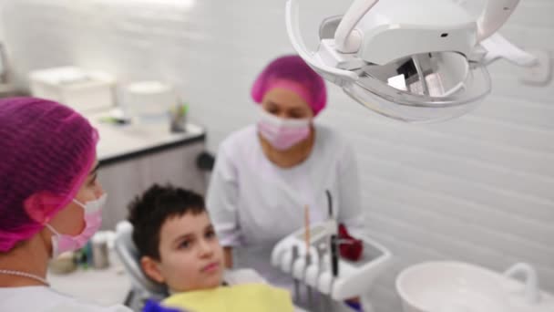 Selektywne Skupienie Się Dentystach Ręcznie Regulujących Lampę Podczas Badania Dziecka — Wideo stockowe