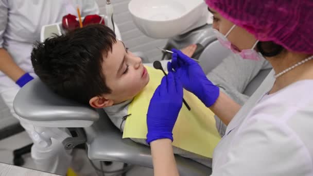 可爱的白人少年男孩在牙医预约 女牙科医生在牙科诊所使用牙镜和探头检查儿童的牙齿和牙龈 牙科口腔医学及医疗保健医学 — 图库视频影像