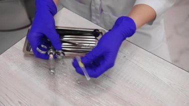 Close-up of dentists hands in medical gloves, loading a syringe with an anesthetic for pain relief