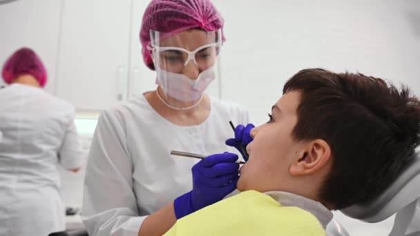 Självsäker Positiv Kvinnlig Tandläkare Hygienist Undersöka Tänder Barn Pojke Sitter — Stockvideo