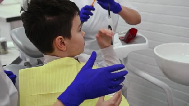 Dentist Assistant Show Boy Patient How Saliva Ejector Sucks Out — Video