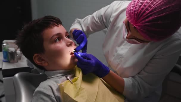 Doctor Dentist Applying Dental Anesthetic Gel Gum Teenage Boy Sitting — Stok Video