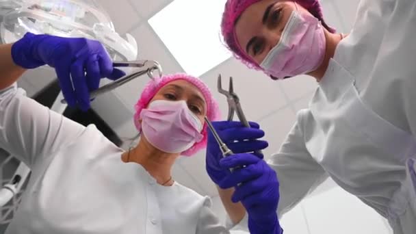 病人的意见 牙科医生和辅助人员 配备了无菌不锈钢牙科器械 用于牙科治疗 倾向于在现代牙科诊所的牙洞工作 卫生保健 口腔科 — 图库视频影像
