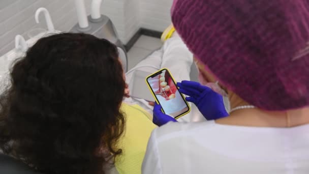 Overhead View Shoulders Dentist Surgeon Using Modern Smartphone Showing Female — 图库视频影像
