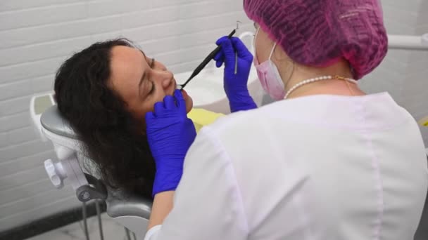 Врач Гигиенист Осматривает Пациентку Помощью Зубного Зонда Зеркала Нержавеющей Стали — стоковое видео