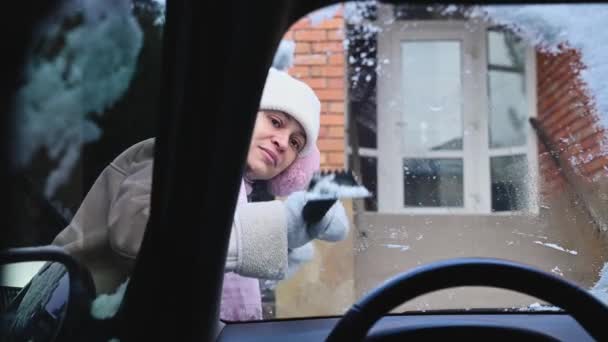 Autofahrerin Mittleren Alters Schabt Und Reinigt Schnee Von Der Windschutzscheibe — Stockvideo