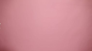 Beyaz kasımpatı ve çingenelerden oluşan şirin bir bahar buketini tutan bir el, pembe renkli bir arka planda bedava reklam alanında beliriyor. Uluslararası Kadınlar Günü. Anneler Günü konsepti