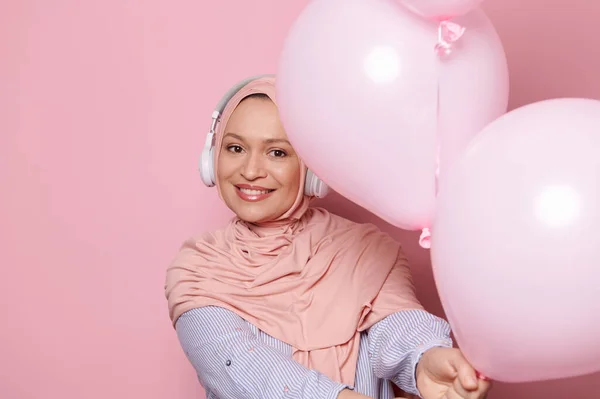 Прекрасна Мусульманка Близького Сходу Одягнена Бездротові Навушники Рожевий Хіджаб Тримаючись — стокове фото