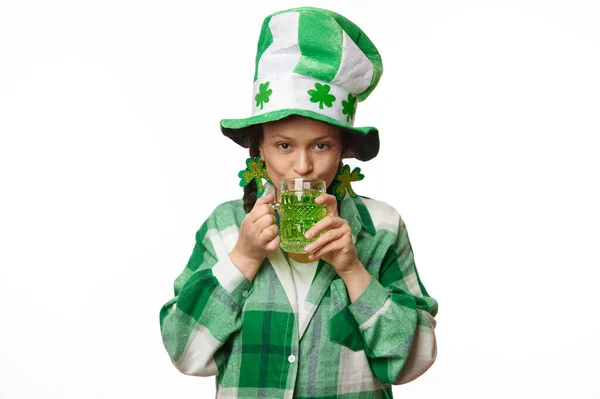 3月17日 圣帕克斯节 一位戴着狂欢节礼帽 头戴三叶草叶和绿色格子衬衫的漂亮女人 看着相机 喝着绿啤酒 与外界隔绝的白色背景一起庆祝 — 图库照片