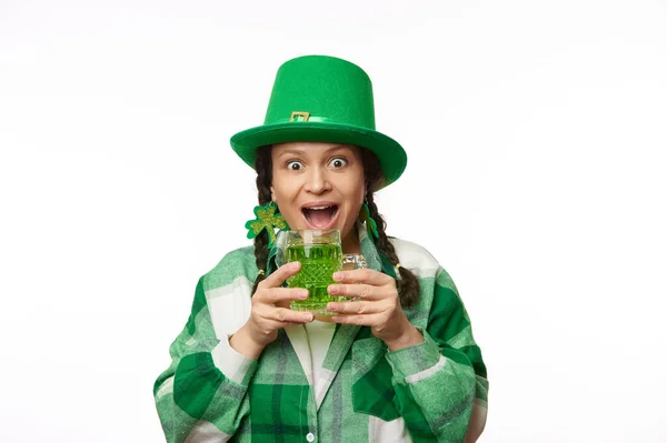 头戴绿帽 头戴三叶草的女人惊讶极了 她表达了积极的情感 手里拿着一大杯美味的绿啤酒 有着孤立的白色背景 圣帕特里克节 爱尔兰文化和传统啤酒节 — 图库照片