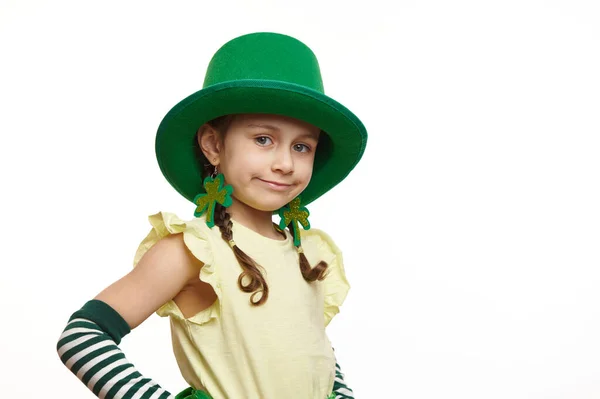 漂亮的5岁小孩 爱尔兰小妖精 头戴绿色狂欢节帽 头戴三叶草形耳环 看着相机 与白色背景隔离 圣帕特里克节 — 图库照片