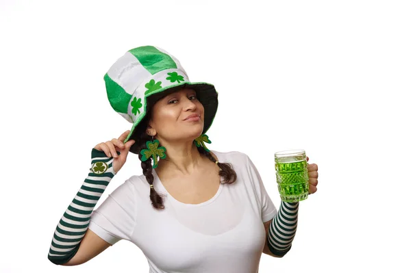 戴着狂欢节礼帽的多民族美女 戴着三叶草叶和条纹手套 手里拿着一大杯绿色啤酒 微笑着看着相机 孤独的白色背景 圣帕特里克节的概念 — 图库照片