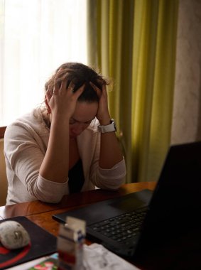 Çok çalışan bir kadın ellerini başının üstüne koyuyor, telefondaki bilgisayarla seyahat ederken gergin bir baş ağrısı hissediyor. İş, stres, insanlar, depresyon, baskı, kariyer, kriz, sorunlar kavramı