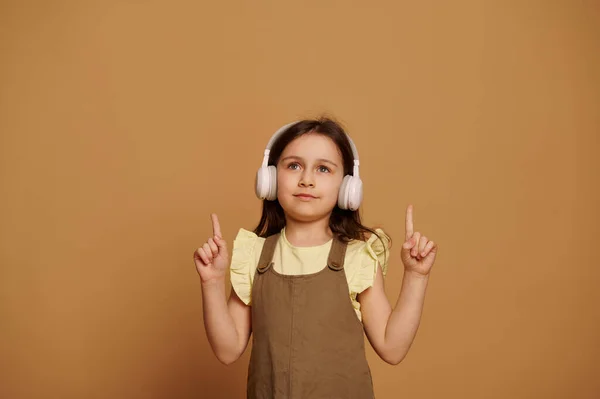 Deliciosa Menina Anos Idade Usando Fones Ouvido Sem Fio Apontando — Fotografia de Stock