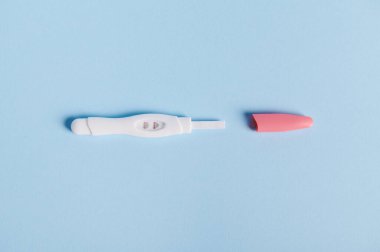 Mavi pastel arka planda iki şeritli pozitif hamilelik testi seti. Annelik kavramı. Kadın sağlığı ve doğurganlık kavramı. Sonunda hamile kaldım. Sağlık sigortası. Düz yatıyordu