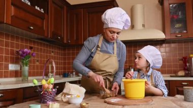Mutlu aile hamur yoğurma, Paskalya bayramı için panettone pişirme. Anne ve kızı şenlikli yemek masası için lezzetli bir kulich hazırlıyorlar. Küçük pasta şefi. Yaşam tarzı. Birlikte mutlu anlar