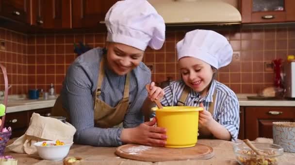 陽気な母親と彼女の愛らしいです5シェフの帽子の歳の娘 一緒に料理を楽しみます 楽しみを持っています 生地を混練し イースター休暇のためのケーキを準備しながら 小麦粉と遊ぶ — ストック動画