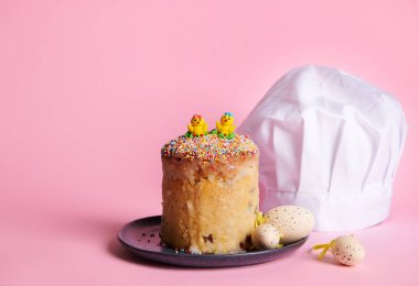 Durgun hayat. Paskalya ekmeği, yumurta ve pembe arka planda beyaz aşçı şapkası. Paskalya aşçılığı dersi için reklam çekimi. Dini Ortodoks ve Katolik bayramı. Yemek konsepti. Fırın. Şekerlemeci.