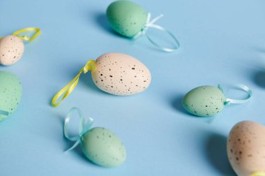 Fotokopi reklam alanı ile izole edilmiş renklerde bej ve mavi renkli pastel Paskalya yumurtalarıyla bembeyaz yatıyordu. Durgun hayat. Paskalya kutlaması. Üst görünüm