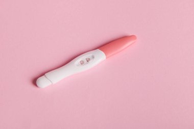 Pembe arka planda pozitif mürekkep jeti hamilelik testi. Evde hızlı hamilelik teşhisi. Reklam alanını kopyala. Kadın sağlığı. Yumurtlama tarihi hesaplaması. Hamilelik ve annelik planlama