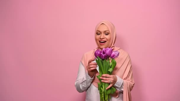Приваблива Мусульманка Рожевому Хіджабі Висловлюючи Щасливий Сюрприз Отримуючи Букет Тюльпанів — стокове відео