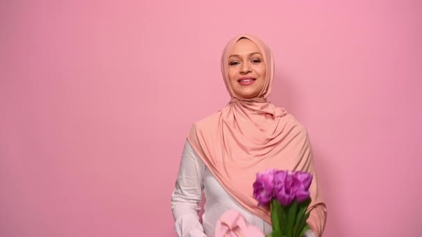 Beautiful Muslim Woman Pink Hijab Showing Camera Bouquet Purple Tulips — Stock Video