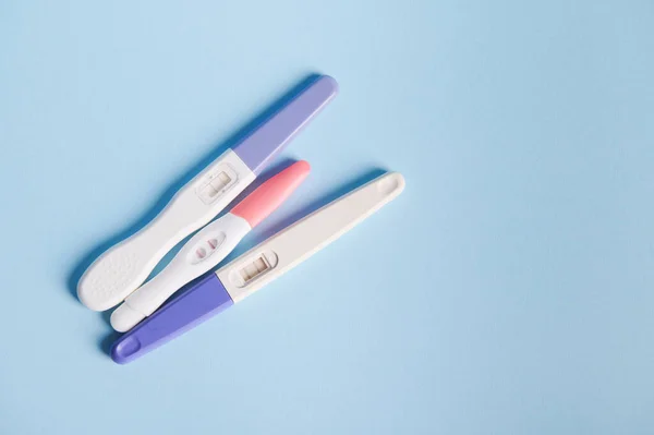 Rapid diagnosis of pregnancy at home. Pregnancy test kits with two bars on isolated blue pastel background. Copy ad space. Womens health, gynecology and medicine concept. Planning maternity concept