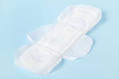 Mavi pastel arka planda izole edilmiş beyaz kadın pedleri. Kadın sağlığı ve regl kavramı