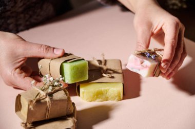 Yakın plan kadınlar el ele tutuşarak ev yapımı soğuk ütülü sabun, gerekli yağlar ve doğal bitkisel malzemeler. Güzellik tedavisi. Deri, saç ve vücut bakımı konsepti. Organik kozmetik ürünleri