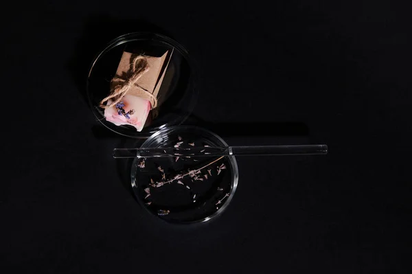 選択的フォーカス ペトリ皿の上のドライラベンダーの花のトップビューと黒を背景に天然成分と石鹸のバー 化粧品学 ボディスキンケアのための有機化粧品 — ストック写真