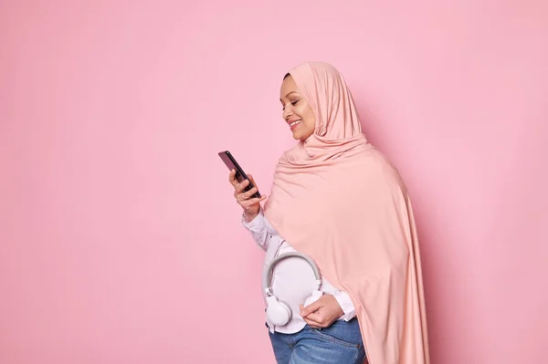 Блаженна Вагітна Мусульманка Рожевому Хіджабі Кладе Навушники Живіт Користується Смартфоном — стокове фото