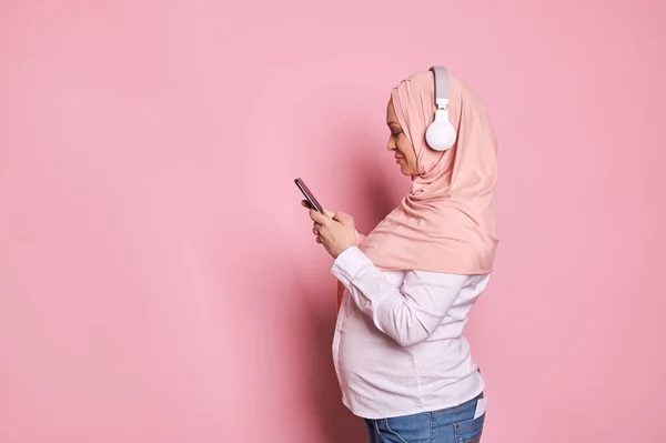 Бічний Портрет Щасливої Арабської Мусульманки Рожевому Хіджабі Навушниками Мобільним Телефоном — стокове фото