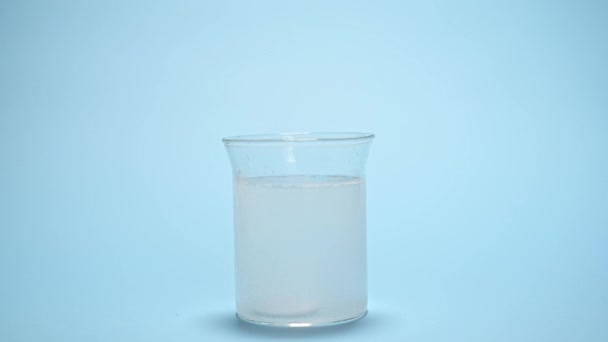 用蓝色底色水溶液溶解玻璃杯中的气泡片 保健和医药 在杯水中溶解的含有泡状药丸的静谧生命 解热药 止痛药 — 图库视频影像