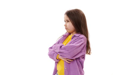 5-6 yaşlarındaki yaramaz beyaz bir kızın beyaz arka planında izole edilmiş bir yan portre, dargınlıkla dudaklarını büzüyor, kollarını kavuşturmuş, yanlış anlaşılmaları ifade ediyor.