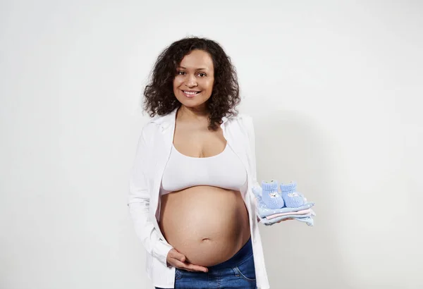 Attraktiv Afroamerikansk Gravid Kvinna Som Håller Nyfödda Kläder Handen Försiktigt — Stockfoto