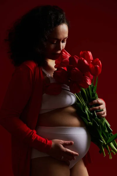 Sidoporträtt Multietnisk Gravid Kvinna Förväntansfull Mor Sniffa Bukett Röda Tulpaner — Stockfoto