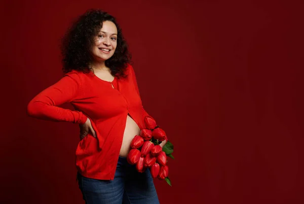 Piękna Wieloetniczna Ciężarna Kobieta Ubrana Czerwoną Koszulę Niebieskie Dżinsy Uśmiechnięta — Zdjęcie stockowe