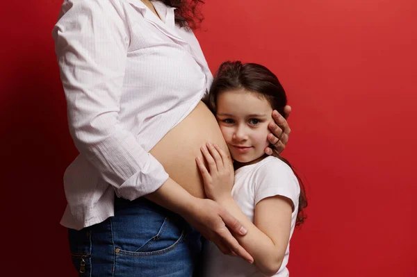 Hermosa Niña Abrazando Vientre Madre Embarazada Mirando Cámara Aislada Sobre —  Fotos de Stock