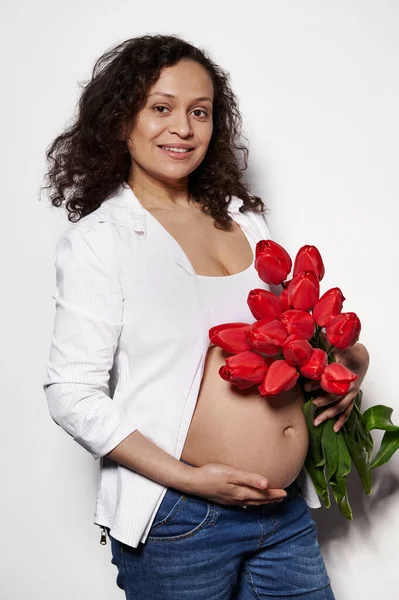 Multietnisk Gravid Kvinna Poserar Naken Mage Med Bukett Röda Tulpaner — Stockfoto