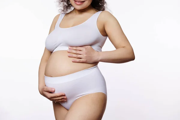 妊娠中の若い女性の真ん中のセクションでは 予期しない灰色の母親は 孤立した背景の上に白い下着を身に着けて ストレッチマークで彼女の裸の腹に手を置く 体のポジティビティ — ストック写真