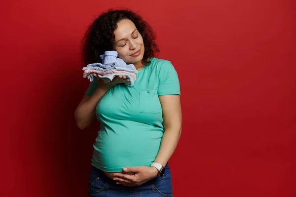 Förtjusande Gravid Kvinna Försiktigt Smeka Magen Hålla Nyfödda Babys Kläder — Stockfoto