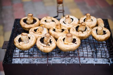 Kapalı çekim Portobello Şampiyonu mantarları dışarıda barbekü partisi yaparken yanan kömürlerin üzerinde ızgara yapıyor. Barbekü. Doğada piknik.