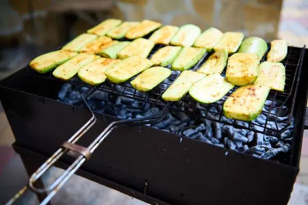 ズッキーニのスライスのクローズアップビューは 味付けされ マリネされ 裏庭で燃える炭バーベキューグリルで調理されます バーベキューパーティーだ オープンエアと夏の寒さで食べ物を準備するという概念 — ストック写真