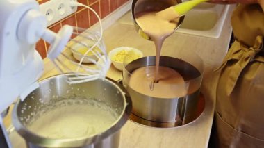 4K video çözünürlüğü. Lezzetli ev yapımı kremalı pasta yapma aşaması. Üçlü çikolata. Erimiş çikolatalı krema dökülüyor. Aşçı, pastacı, doğum günü için tatlı hazırlıyor.