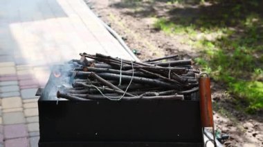 Arka bahçedeki barbekü ızgarasında yanan ağaç dalları tepemizde. Açık havada yemek hazırlıyorum. Yaz rahatlama ve piknik konsepti. Barbekü yaz partisi