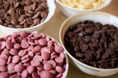 Kâselerdeki organik Belçika çikolatası parçalarının yakın çekimi. Jöle, tatlı ve çeşitli hamur işleri hazırlamak için gerekli malzemeler. Yemek arkaplanı. Durgun hayat. Seçici odaklanma. Mutfak. Tatlı yemek.