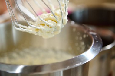 Pasta ve tatlı tatlılar için krem şanti yakın plan. Krem şantiyi sert tepelere ya da gezegen mikserinde yumurta beyazına çevirme işlemi. Durgun hayat. Seçici odak