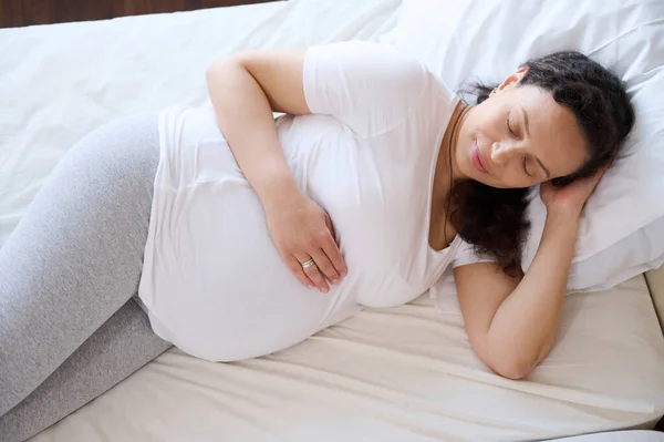 一个安静迷人的年轻35岁的准妈妈一个人躺在卧室里 休息一下 重新焕发出无忧无虑的活力 怀孕的概念 怀孕三个月第三次 — 图库照片