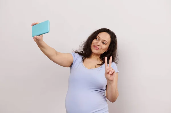 Mooie Zwangere Vrouw Toont Vrede Teken Nemen Selfie Smartphone Gesprekken — Stockfoto